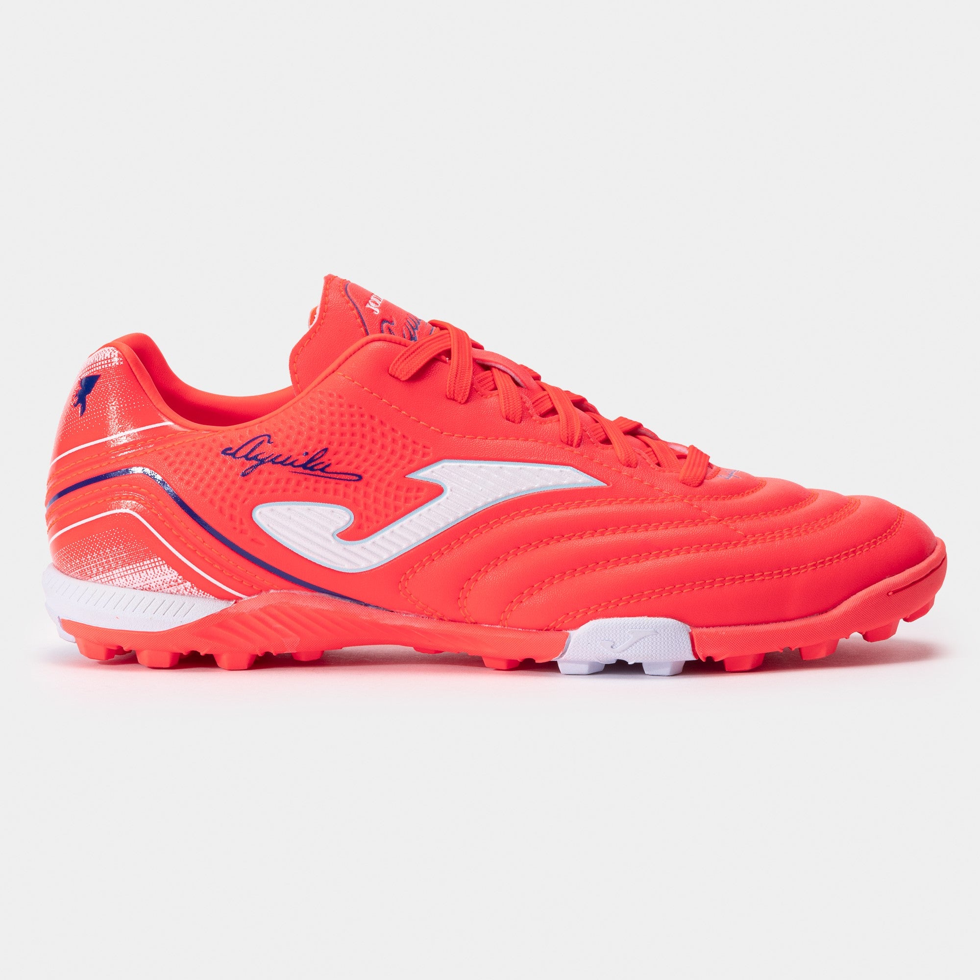 Joma Aguila 2507 turf soccer shoes in orange – side view showing synthetic leather upper and turf outsole.