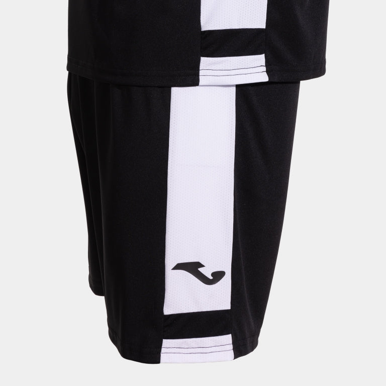 Black and white sports shorts with a brand logo on a light gray background