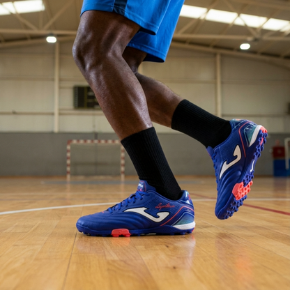 Person wearing blue sports shoes with red accents on a basketball court