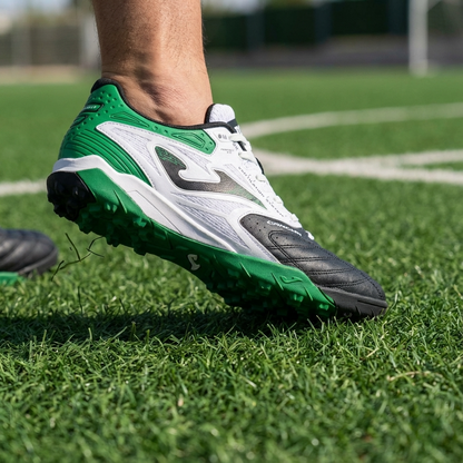 Green and white soccer cleat on a grass field